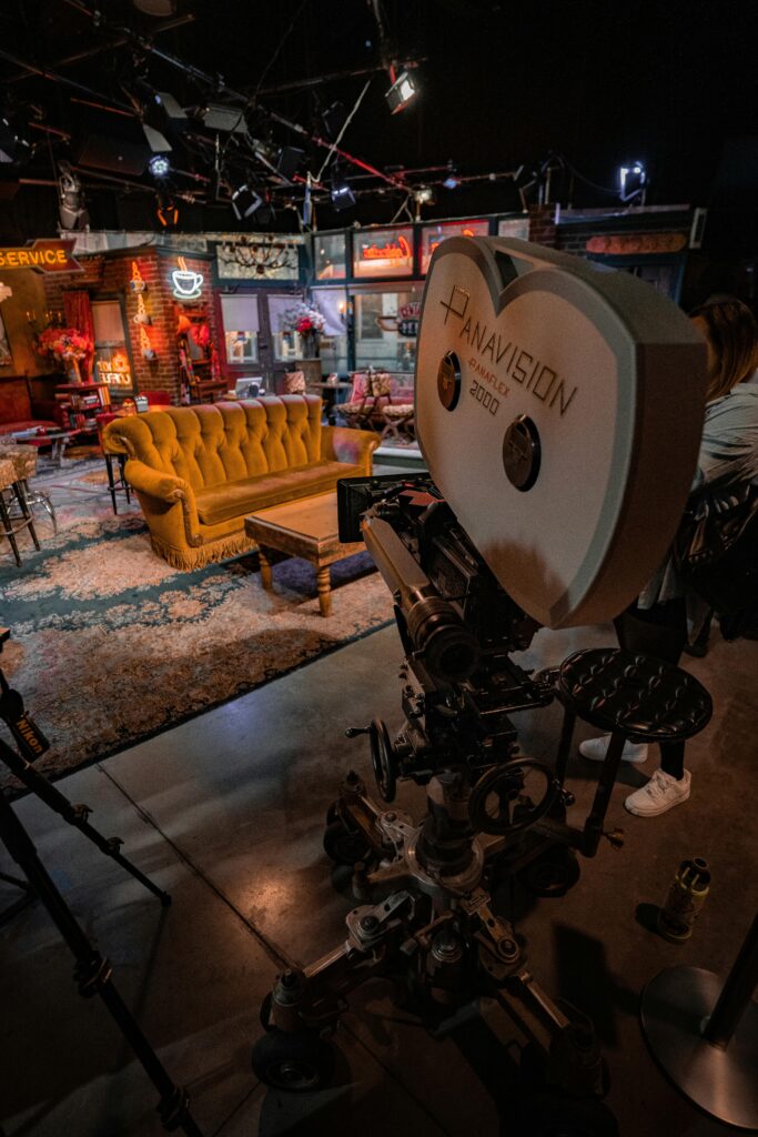 A vintage Panavision camera in a TV studio set with iconic Central Perk couch.