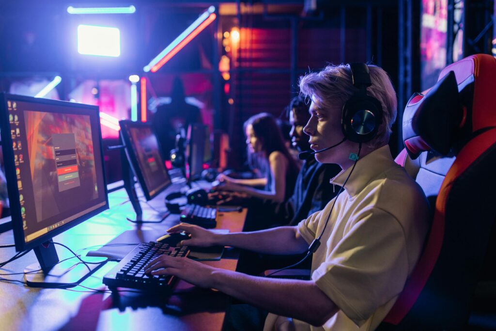 pexels-photo-7862517-7862517 Gamers engaged in a competitive session, equipped with headsets and monitors in an immersive setup.