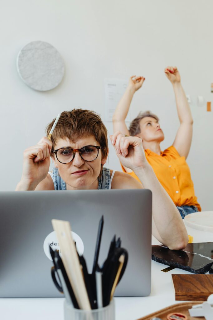 Two women working together on a project indoors, focusing and brainstorming.