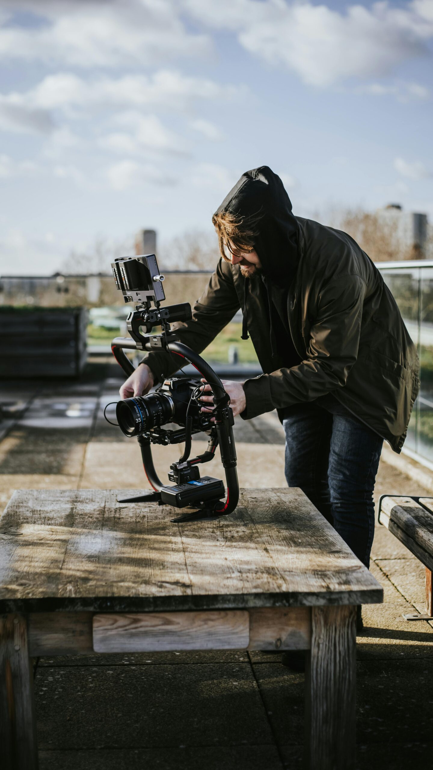 A photographer prepares a camera on a stabilizer for outdoor filming in London.